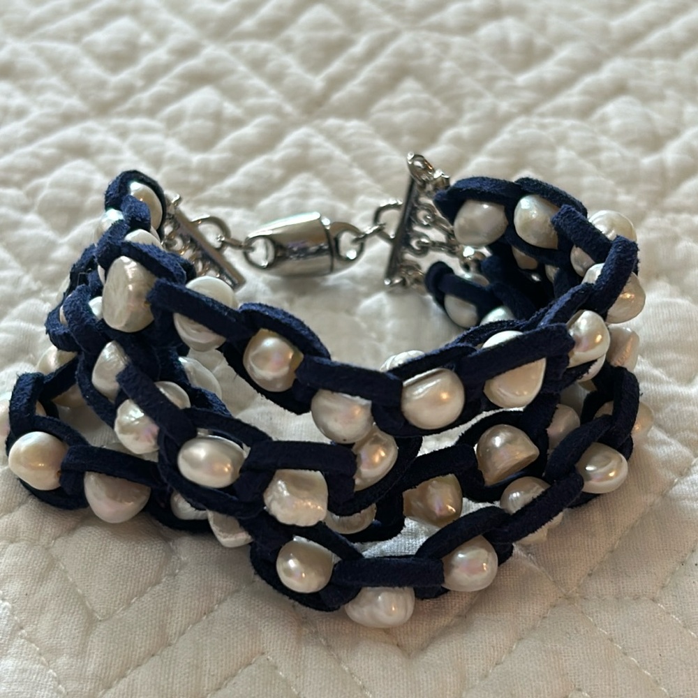 Four stands of faux pearls wrapped in blue faux suede bracelet.